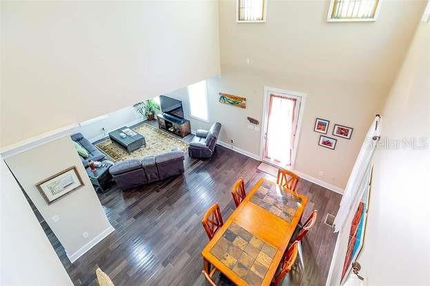 An elevated view of a living and dining area with dark wood floors and high ceilings — 204 VIRGINIA AVENUE, STEINHATCHEE, FL