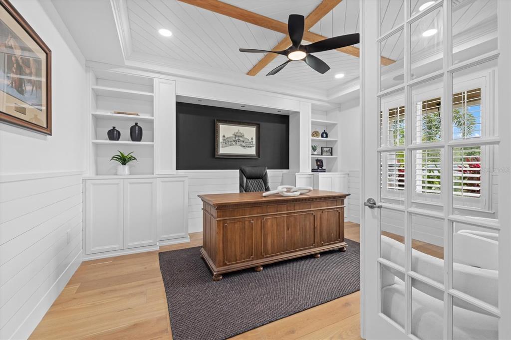 A home office features a wooden desk, built-in white shelving, and a dark accent wall — 3214 ANCHOR BAY TRAIL, BRADENTON, FL