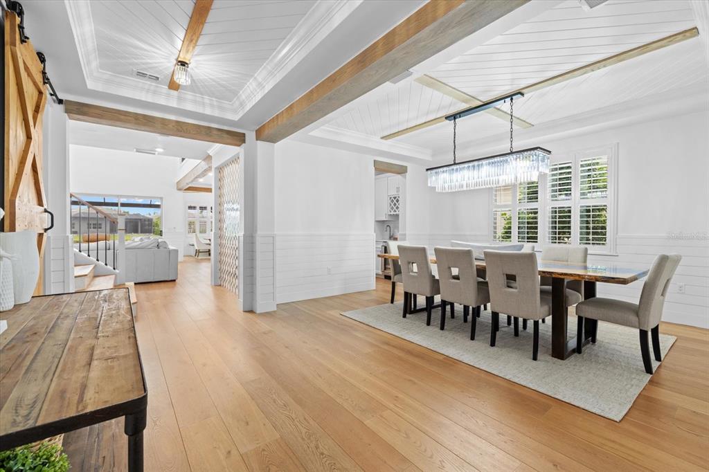 A dining room with a long table, chandelier, and wood-paneled ceiling beams — 3214 ANCHOR BAY TRAIL, BRADENTON, FL