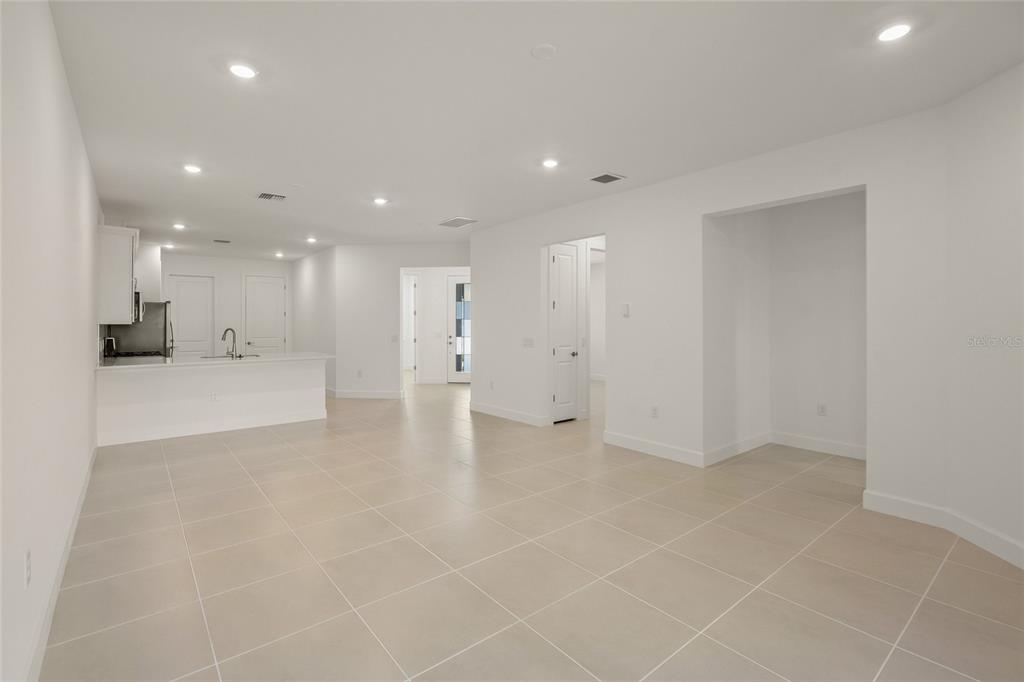 An open-concept living area features white walls, recessed lighting, and light-colored tile flooring — 14860 MISTY POND LOOP, NOKOMIS, FL