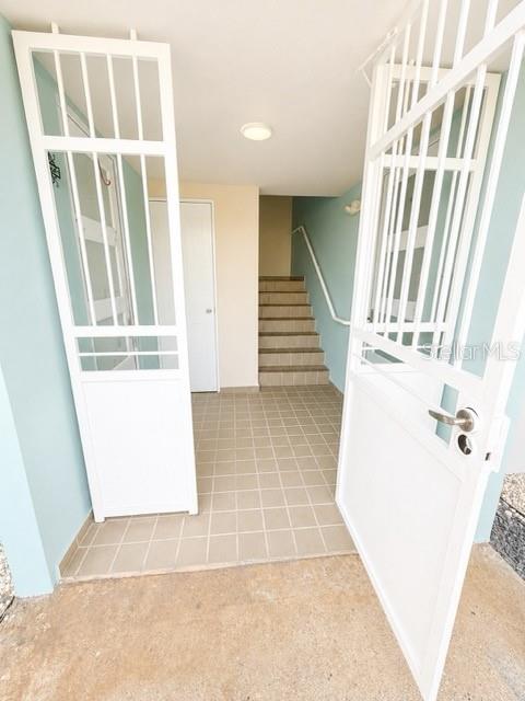 An entryway with white security gates, tiled flooring, and a staircase leading to an upper level — 1203 GOLDEN VILLAS, VEGA ALTA, PR