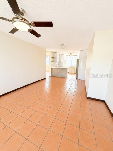 An open-concept living area features light-colored walls, a ceiling fan, and terracotta floor tiles — 1203 GOLDEN VILLAS, VEGA ALTA, PR