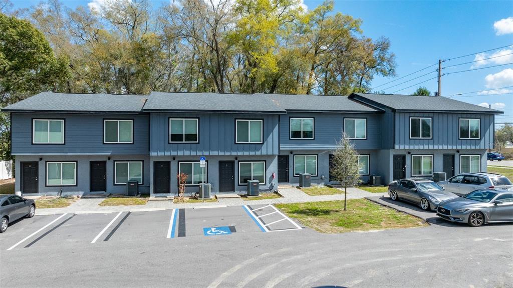 A multi-unit residential building with blue siding and a parking lot in the foreground — 3041 SW 20TH STREET, OCALA, FL