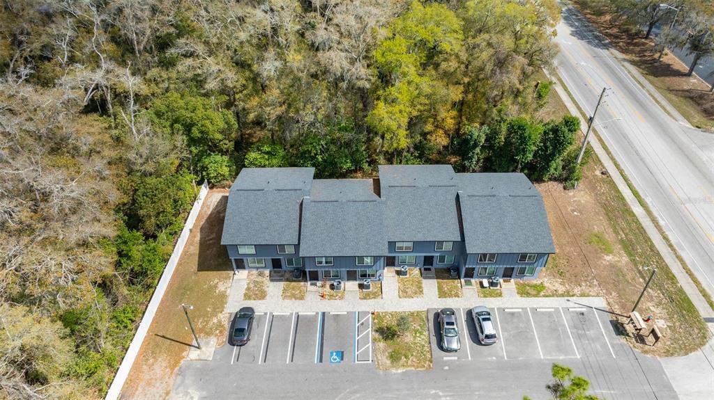 An aerial view shows a multi-unit residential building with a parking lot and wooded area — 3041 SW 20TH STREET, OCALA, FL