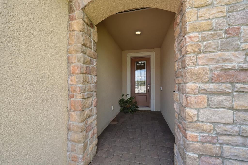 An entryway features a white front door, marble-look tile flooring, and framed art on walls — 13038 PRIMA DRIVE, BRADENTON, FL