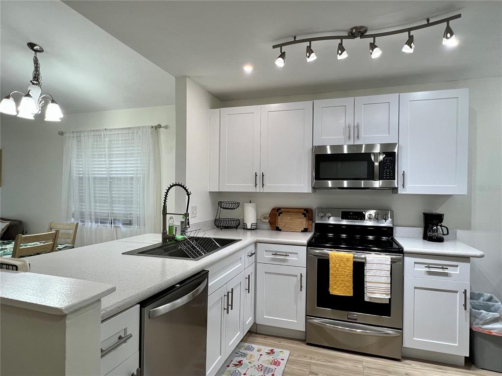 A kitchen with white cabinets, stainless steel appliances, and a track lighting fixture — 962 STONYBROOK CIRCLE, PORT ORANGE, FL