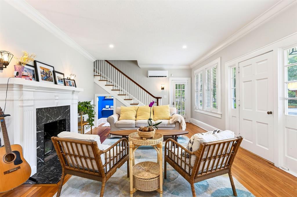 A living room features a fireplace, a staircase, two rattan chairs, and a sofa — 128 WISTERIA AVENUE, ORLANDO, FL