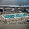 An outdoor rectangular swimming pool is situated in front of a multi-story apartment building — 1400 EUDORA ROAD UNIT D-38, MOUNT DORA, FL
