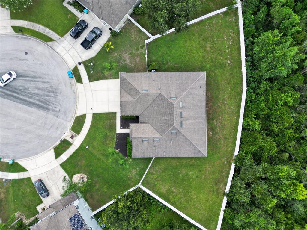 An aerial view shows a house with a gray roof, a driveway, and a fenced yard — 1458 DAYSTAR LANE, DELTONA, FL