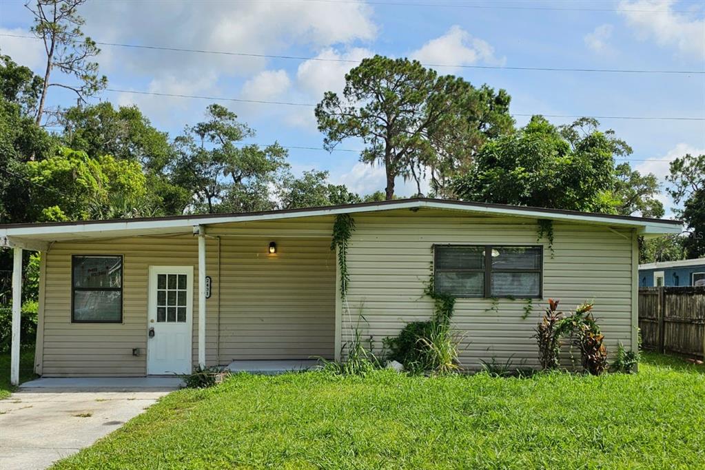 A single-story house with beige siding, a covered front porch, and a concrete driveway — 2431 CANNON STREET, LAKELAND, FL