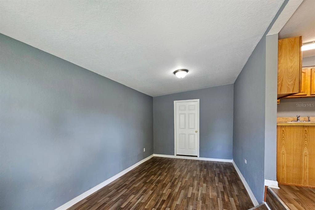 An empty room with gray walls, wood-look flooring, and a white door — 2431 CANNON STREET, LAKELAND, FL