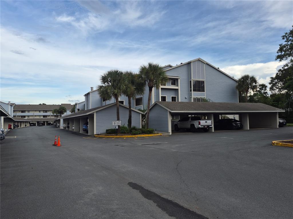 A kitchen features cream-colored cabinets, stainless steel appliances, dark granite countertops, and tiled flooring — 4101 FAIRVIEW VISTA POINT UNIT 230, ORLANDO, FL