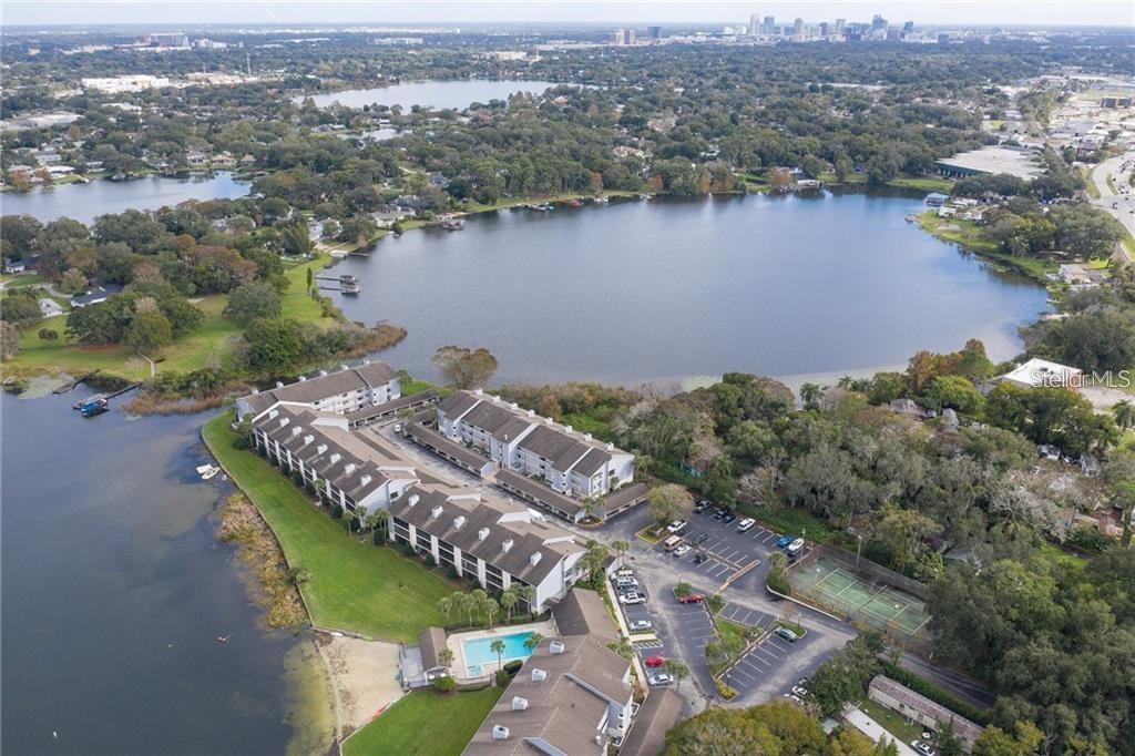A kitchen features off-white cabinets, dark granite countertops, stainless steel appliances, and tile flooring — 4101 FAIRVIEW VISTA POINT UNIT 230, ORLANDO, FL