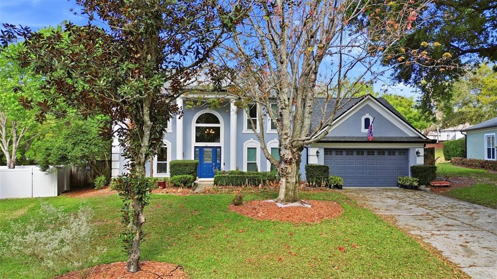 A two-story house with a blue front door, gray siding, and an attached garage — 1311 OLYMPIA PARK CIRCLE, OCOEE, FL