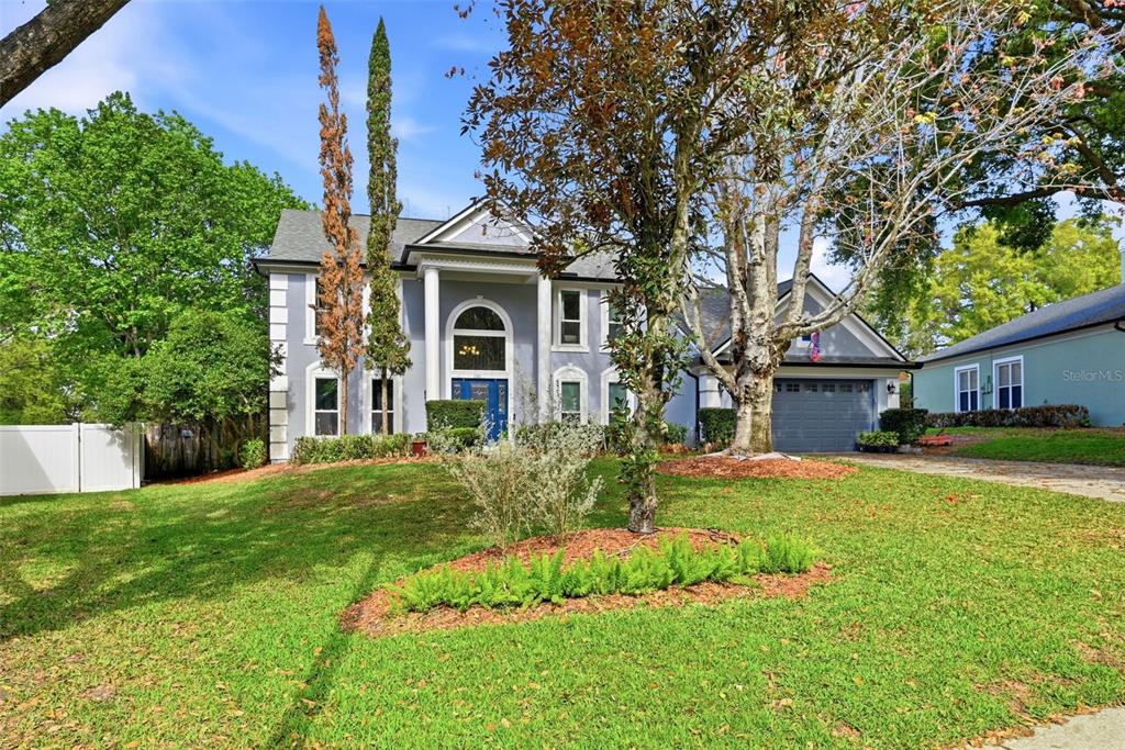 A two-story gray house with a blue front door and a two-car garage — 1311 OLYMPIA PARK CIRCLE, OCOEE, FL