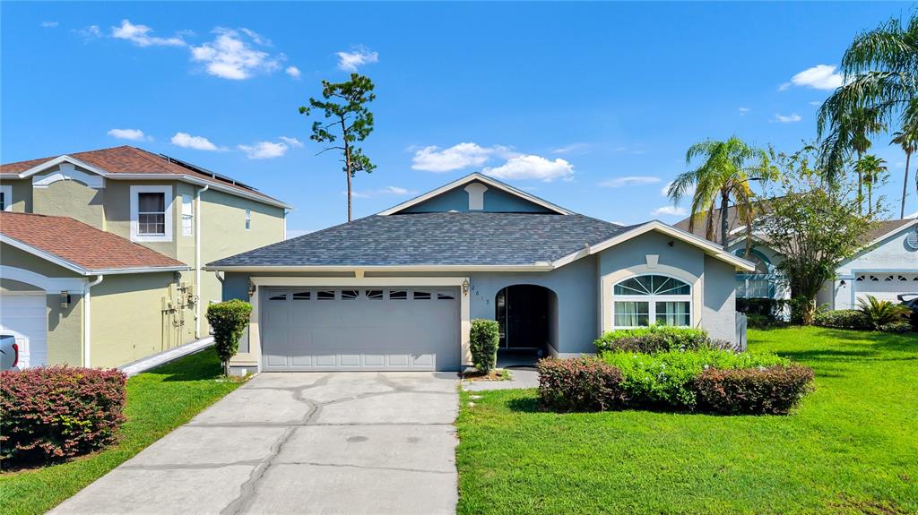 A single-story house with a gray garage, blue exterior, and a manicured front lawn — 2619 HERON LANDING COURT, ORLANDO, FL
