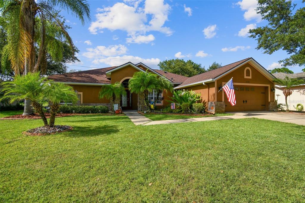 A single-story house with a brown exterior, a two-car garage, and a front lawn — 16920 FALCONRIDGE ROAD, LITHIA, FL