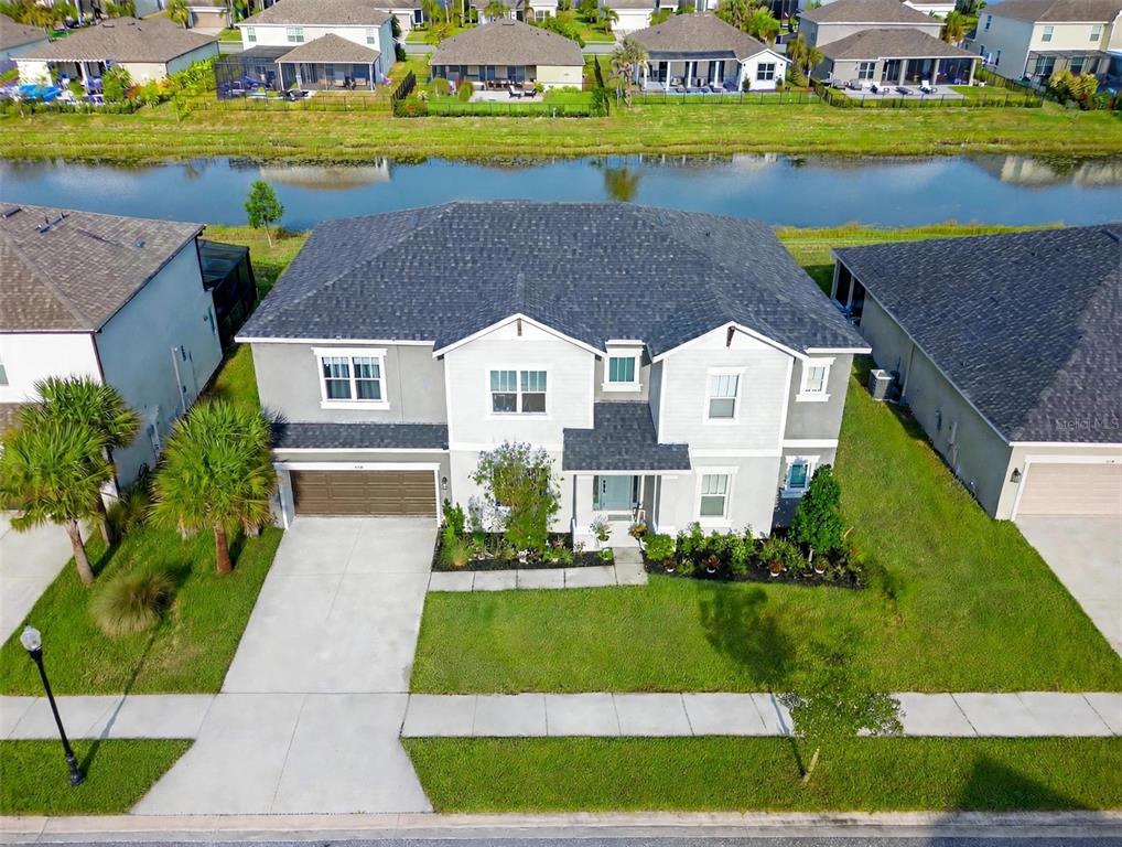 A two-story suburban house with a two-car garage and two parked cars in the driveway — 7228 BRADBURY CIRCLE, WESLEY CHAPEL, FL