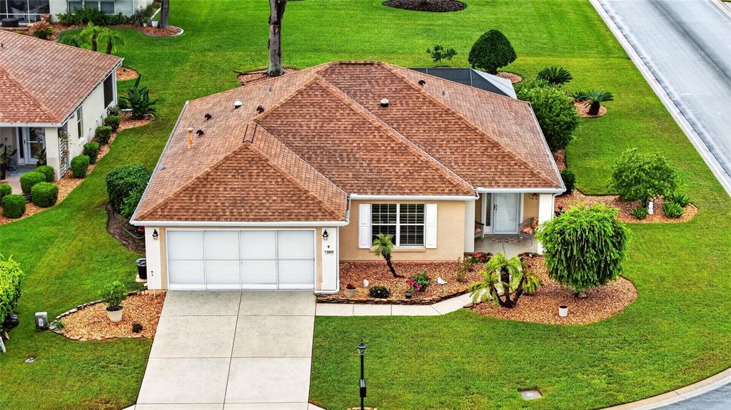 An aerial view of a single-story suburban house with a brown shingled roof and driveway — 13806 SE 93RD AVENUE, SUMMERFIELD, FL