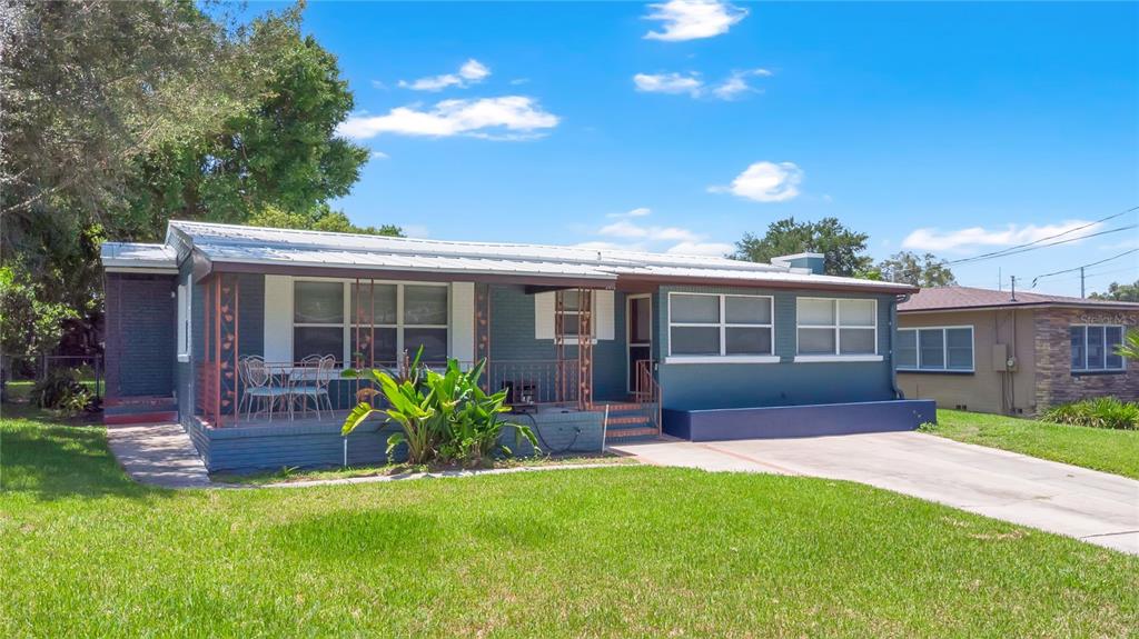A single-story house with a dark green brick exterior and a covered front porch — 2418 E JERSEY AVENUE, ORLANDO, FL
