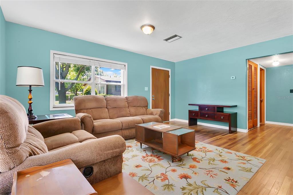 A kitchen with teal walls, white cabinets, granite countertops, and a modern sputnik chandelier — 2418 E JERSEY AVENUE, ORLANDO, FL