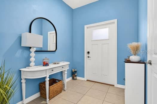 An entryway features light blue walls, a white console table with a mirror, and tile flooring — 6119 SHINER STREET, LAND O LAKES, FL