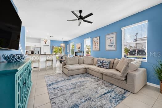 A living room with a sectional sofa, blue walls, and an open kitchen with bar seating — 6119 SHINER STREET, LAND O LAKES, FL