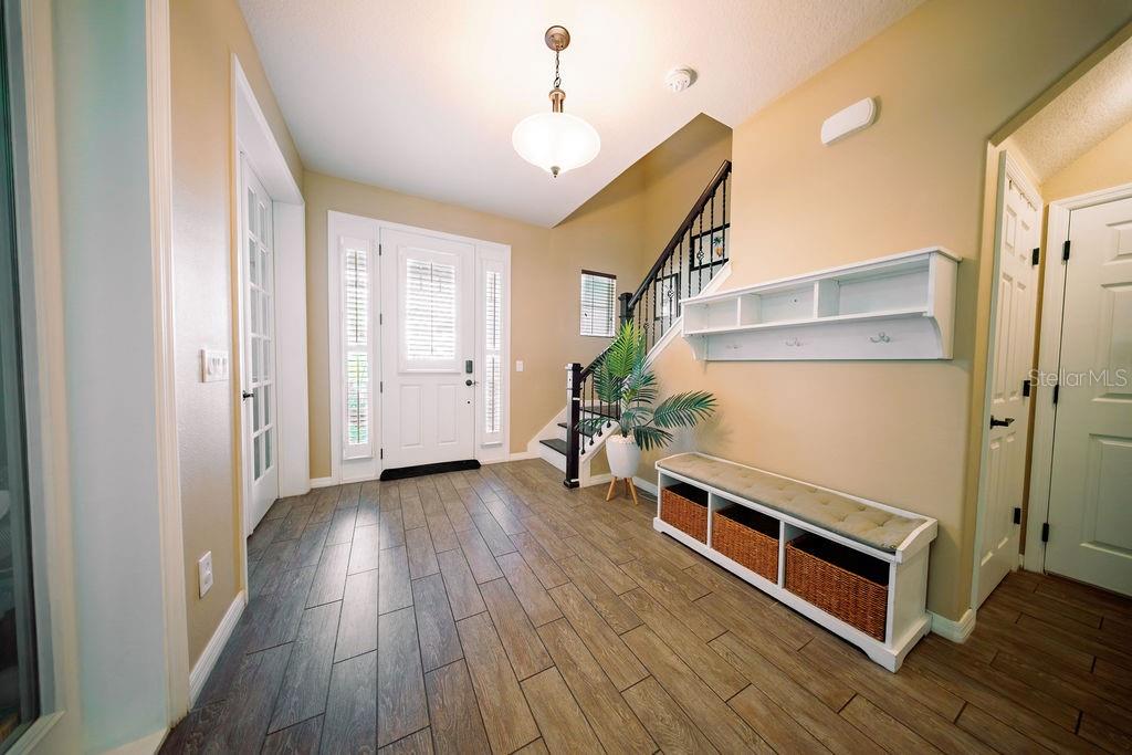 A home office features built-in white shelving, a dark wood desk, and a brown leather sofa — 8173 GAMEMASTER AVENUE, ORLANDO, FL
