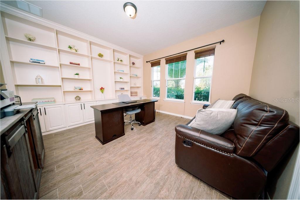 A home gym features a stationary bike, a cable machine, and various free weights — 8173 GAMEMASTER AVENUE, ORLANDO, FL