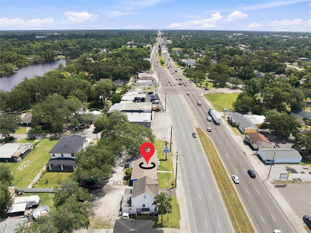 An aerial view shows a commercial building with a red location pin along a highway — 901 W HILLSBOROUGH AVENUE, TAMPA, FL