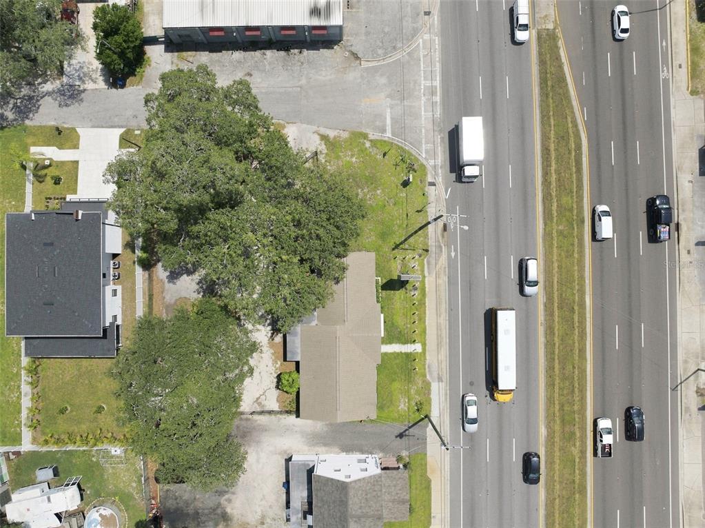 An aerial view shows a building with a large tree next to a busy highway — 901 W HILLSBOROUGH AVENUE, TAMPA, FL