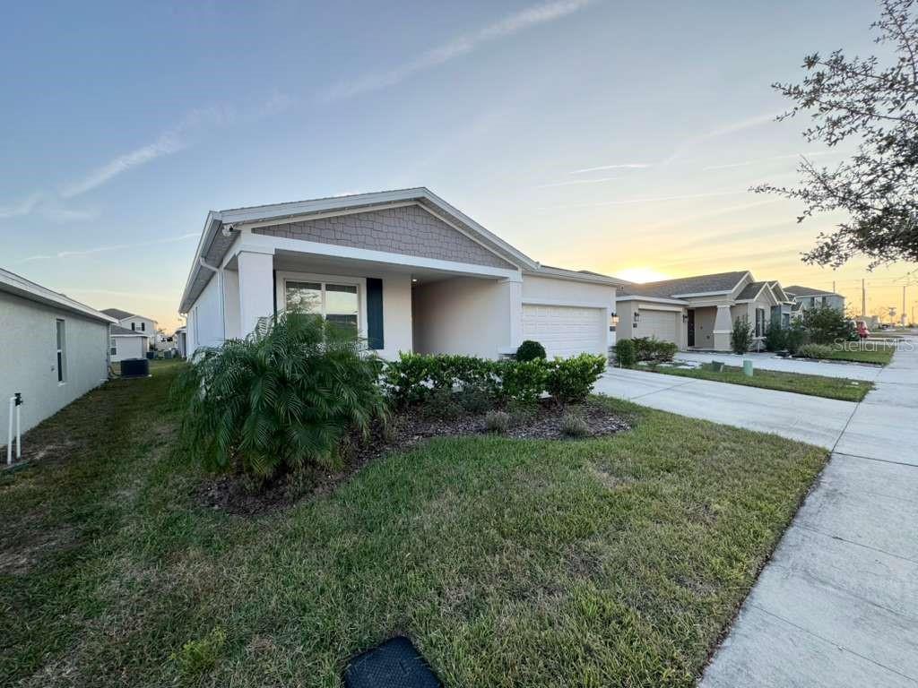 A single-story suburban house with a white exterior, a front porch, and a concrete driveway — 1180 SAGUARO STREET, HAINES CITY, FL