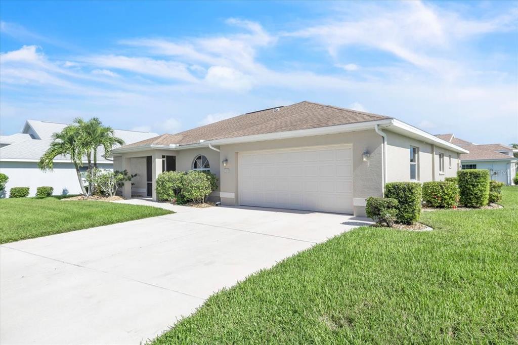 A single-story house with a beige stucco exterior, a two-car garage, and a manicured lawn — 3455 SABAL SPRINGS BOULEVARD, NORTH FORT MYERS, FL