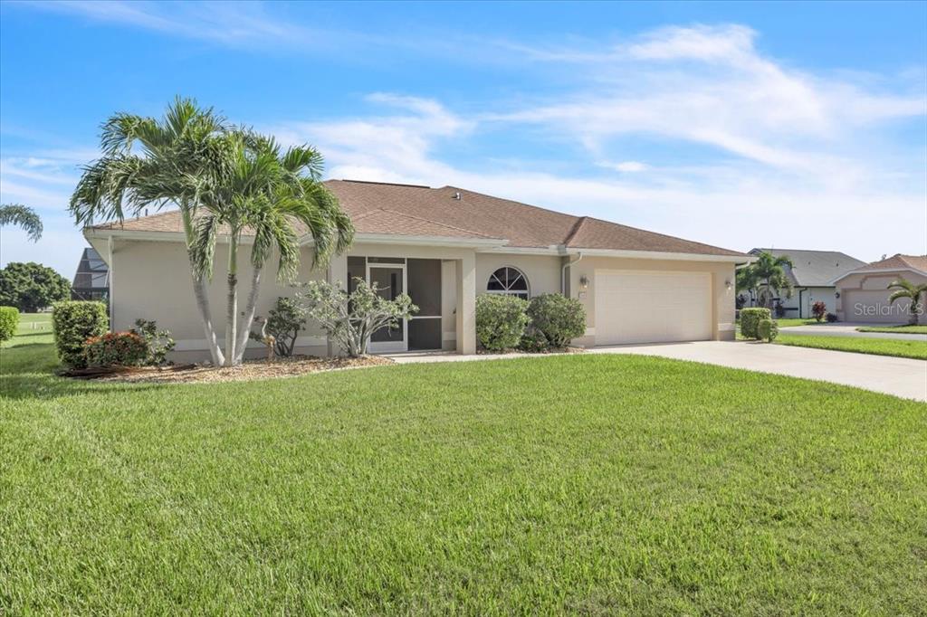 A single-story house with a tan stucco exterior, a two-car garage, and a palm tree — 3455 SABAL SPRINGS BOULEVARD, NORTH FORT MYERS, FL