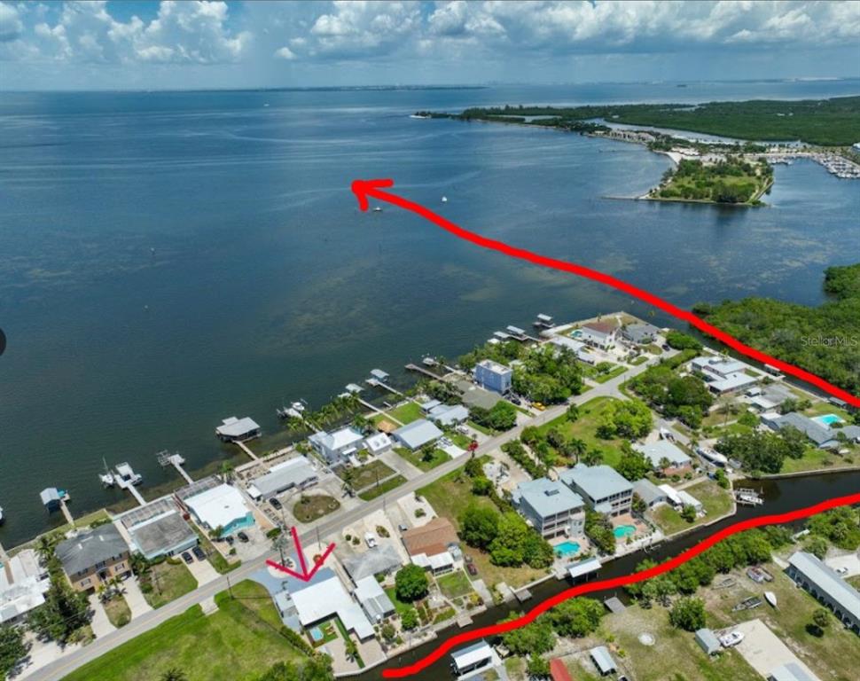 An aerial view shows a waterfront house with a boat dock and a canal — 3503 W SHELL POINT ROAD, RUSKIN, FL