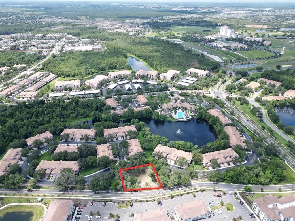An aerial view shows a vacant rectangular lot outlined in red within a residential complex — 1320 S GOODMAN ROAD, DAVENPORT, FL