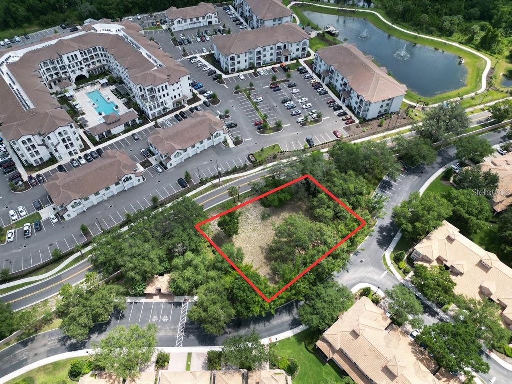 An aerial view shows a vacant, rectangular plot of land outlined in red near apartments — 1320 S GOODMAN ROAD, DAVENPORT, FL