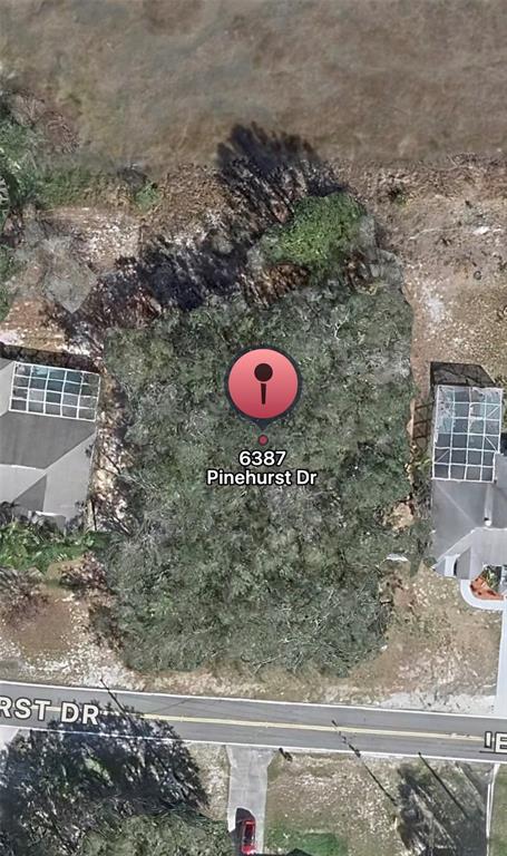This is an aerial map view of a wooded, vacant residential lot between two houses — 6387 PINEHURST DRIVE, SPRING HILL, FL