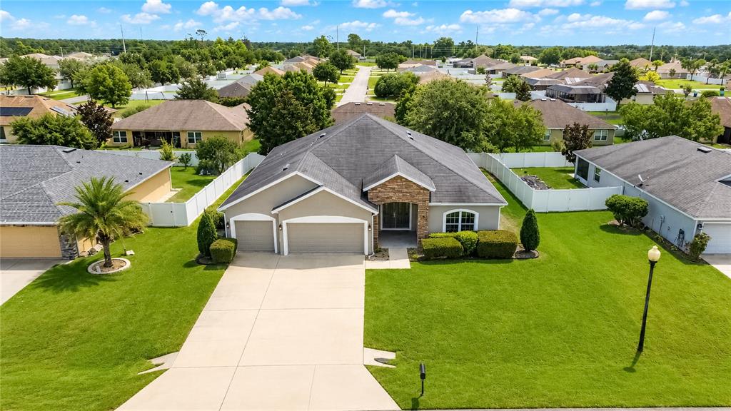 An aerial view of a single-story suburban house with a stone facade and attached garage — 9857 SW 51ST COURT, OCALA, FL