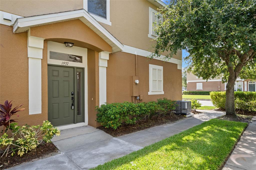 A tan two-story building features a green front door under a covered entryway — 1937 ESTANCIA CIRCLE UNIT 1937, KISSIMMEE, FL