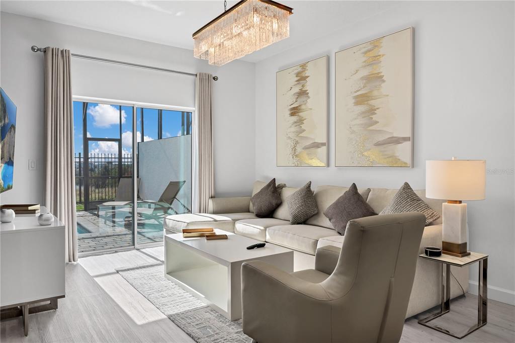A living room features a sectional sofa, a coffee table, and a sliding glass door — 412 FAMAGUSTA, DAVENPORT, FL
