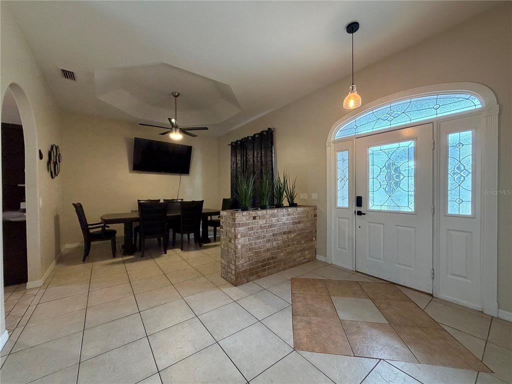 A dining area with a brick half-wall divider sits adjacent to a tiled entryway — 51 FANSHAWE LANE, PALM COAST, FL