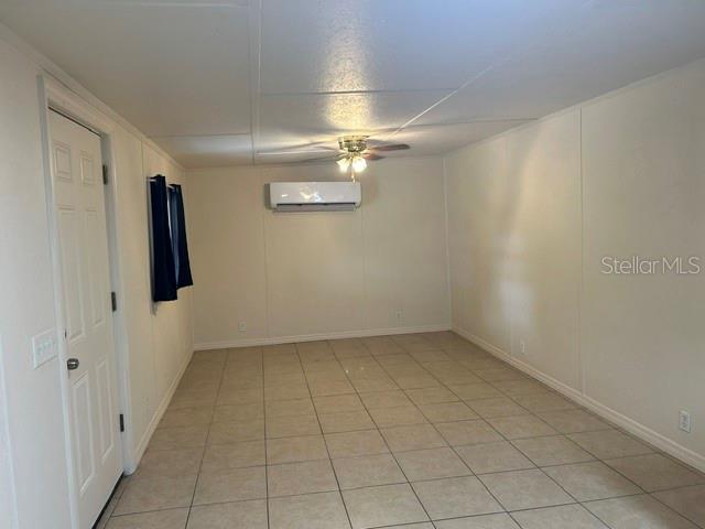 An interior room features light-colored tile flooring, a ceiling fan, and a wall-mounted air conditioner — 1481 NOCATEE STREET, INTERCESSION CITY, FL