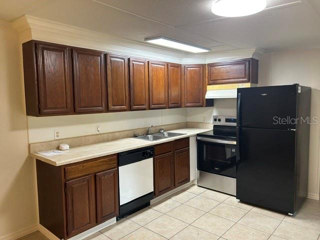 A kitchen features dark wood cabinets, a black refrigerator, and a stainless steel stove — 1481 NOCATEE STREET, INTERCESSION CITY, FL