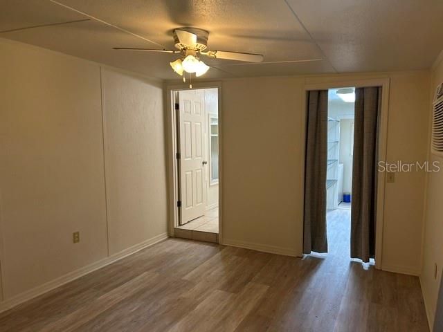An interior room with light wood-look flooring, a ceiling fan, and two doorways — 1481 NOCATEE STREET, INTERCESSION CITY, FL