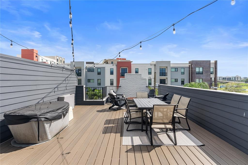 A rooftop deck features a hot tub, dining set, and string lights against city buildings — 417 W ROSS AVENUE UNIT 2, TAMPA, FL