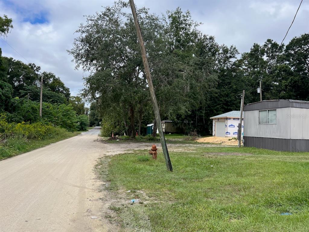 A dirt road leads past a fire hydrant, a utility pole, and a small building — 000 NE 40TH PLACE, WILLISTON, FL