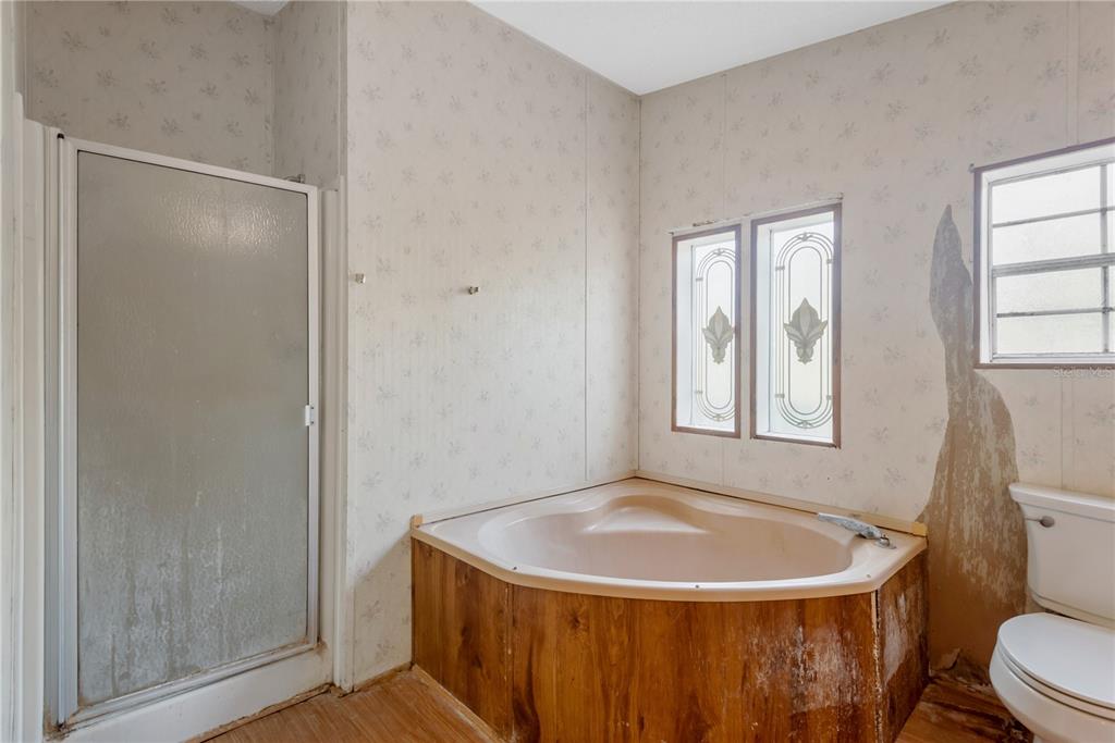 A bathroom features a corner soaking tub, a glass shower stall, and a toilet — 11620 E BAY ROAD, GIBSONTON, FL