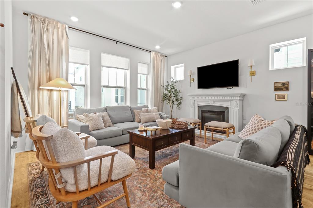 A living room features two gray sofas, a wooden coffee table, and a fireplace — 923 COLIE ALLEY, WINTER GARDEN, FL