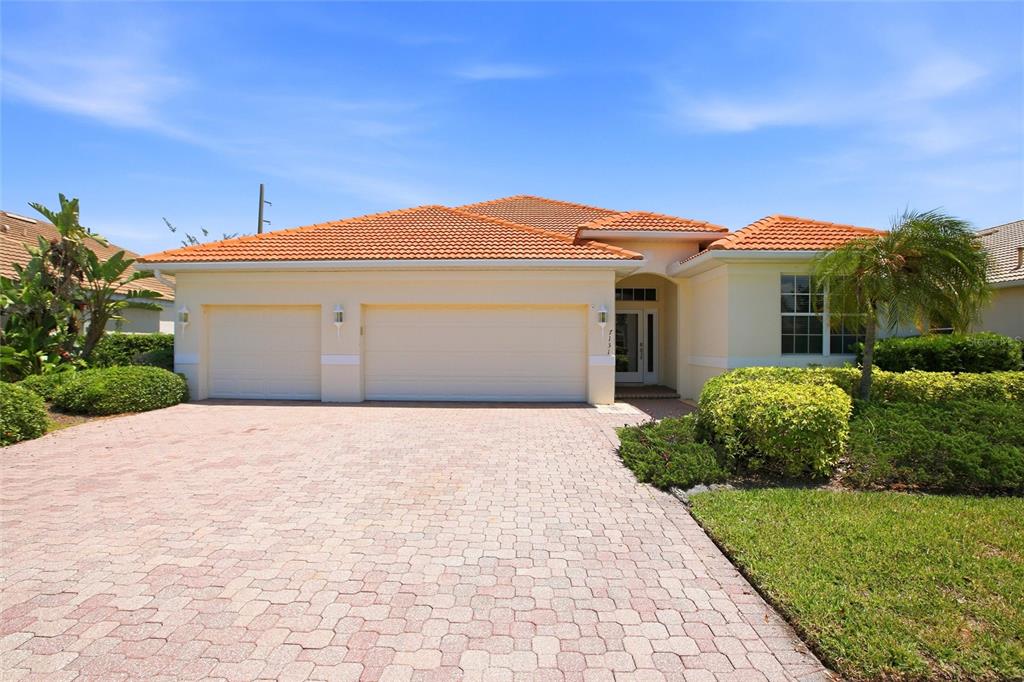 A single-story house with a tiled roof, a three-car garage, and a paved driveway — 7131 67TH TER E, BRADENTON, FL